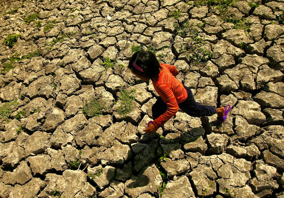 A Filipino child walks through a dried-up irrigation canal in the province of Cavite.