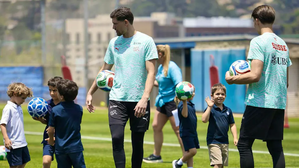Goalies Gregor Kobel and Marvin Keller train with the kids (KEYSTONE/Peter Klaunzer)