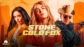 Filmmotiv zu «Stone Cold Fox» mit zwei Frauen und einem Mann mit Cowboyhut und Revolver vor orangefarbener Kulisse.
