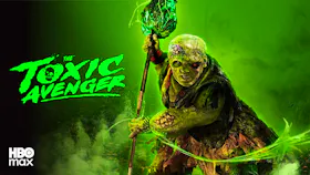 Filmmotiv zu «The Toxic Avenger» mit einer grün leuchtenden, entstellten Figur, die einen Stab in den Händen hält.