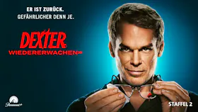 Michael C. Hall als Dexter mit leichtem Lächeln putzt seine Brille mit einem Blutfleck